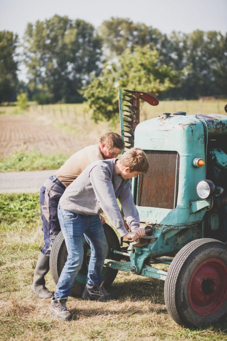 Landwirtschaft hautnah Mann und Junge werkeln auf einem Feld bei der Biberburg gemeinsam an einer alte Landmaschine