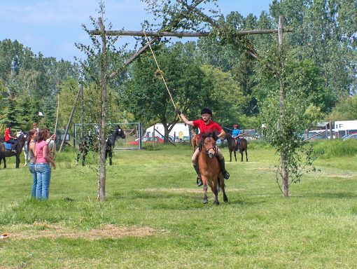 Kranzreiten im Wettbewerb Reiter auf Pony bei einem Kranzreiten-Turnier auf der Wiese des Landhotel Biberburg
